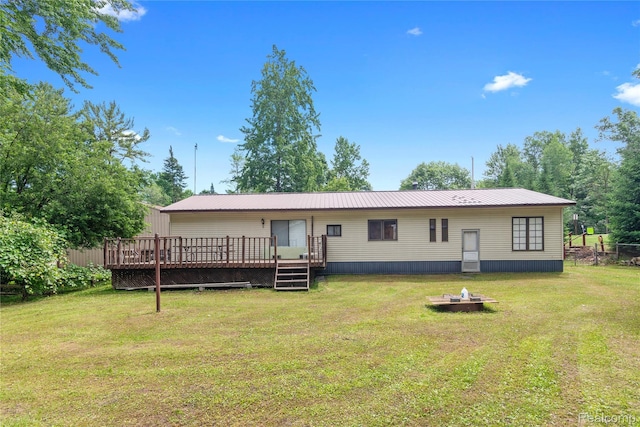 4175 Cherokee St, Gladwin, MI 48624 - rear view of house featuring a wooden deck, a metal roof, and a fire pit