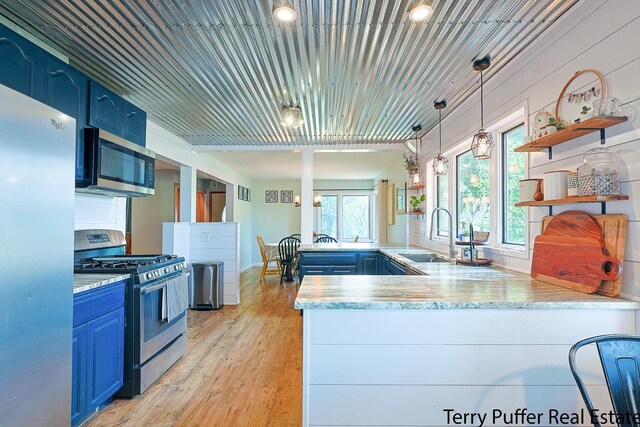 721 17 Mile Rd, Kent City, MI 49330 - kitchen with blue cabinetry, stainless steel appliances, a peninsula, and open shelves