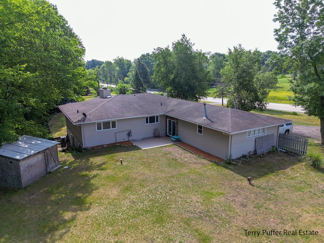 721 17 Mile Rd, Kent City, MI 49330 - back of property featuring a patio area, a yard, a shingled roof, and an outdoor structure