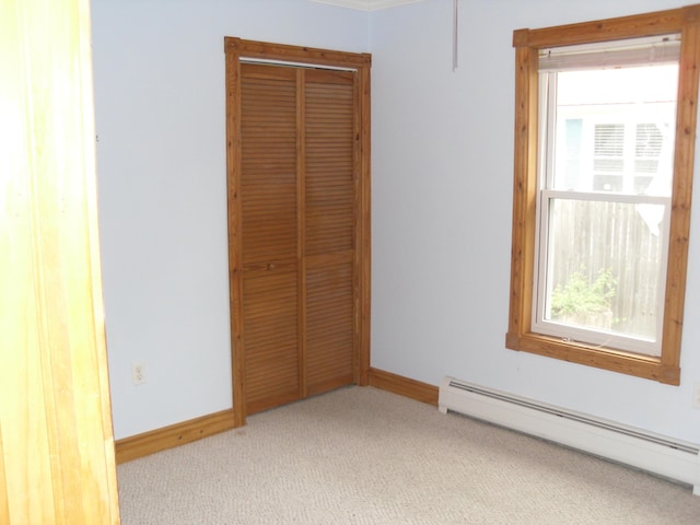 812 N Rath Ave, Ludington, MI 49431 - unfurnished bedroom featuring baseboard heating, light carpet, and a closet