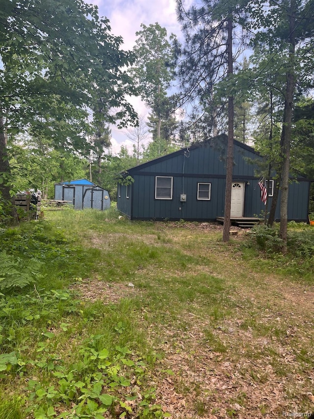 1185 E Hughes Lake Rd, Rose City, MI 48654 - back of property with board and batten siding and a storage shed