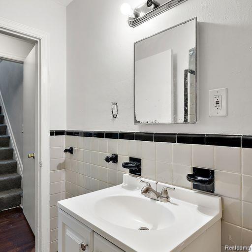 19405 Pierson St, Detroit, MI 48219 - bathroom featuring vanity, tile walls, wood finished floors, and wainscoting