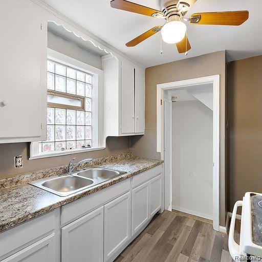 19405 Pierson St, Detroit, MI 48219 - kitchen featuring range, white cabinets, wood finished floors, and light countertops