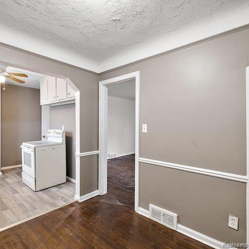 19405 Pierson St, Detroit, MI 48219 - kitchen featuring washer / dryer, light wood-style flooring, white cabinets, a ceiling fan, and arched walkways