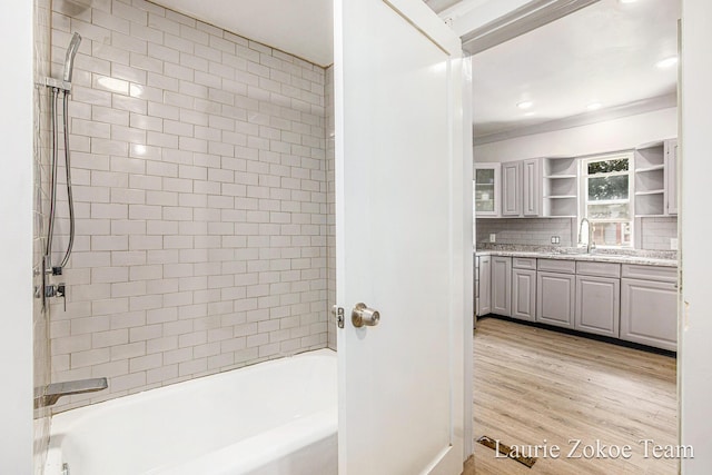 1101 White Ave NW, Grand Rapids, MI 49504 - bathroom featuring double vanity, tasteful backsplash, wood finished floors, and  shower combination