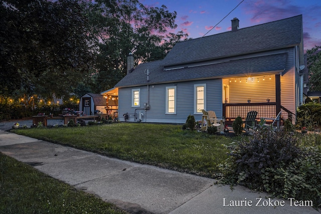 1101 White Ave NW, Grand Rapids, MI 49504 - view of front of property featuring a front yard, a shingled roof, an outdoor fire pit, and a chimney