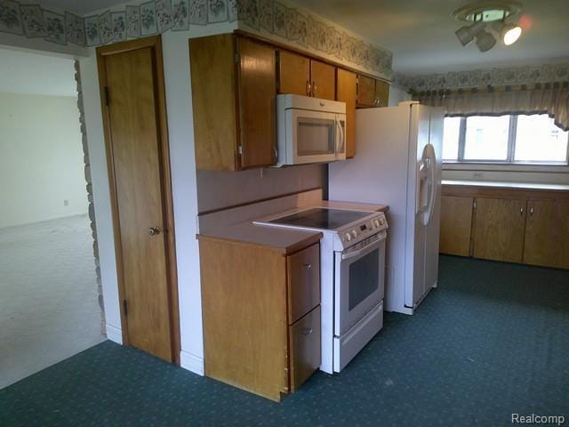 7776 Ash St, Birch Run, MI 48415 - kitchen with white appliances, carpet flooring, and brown cabinets