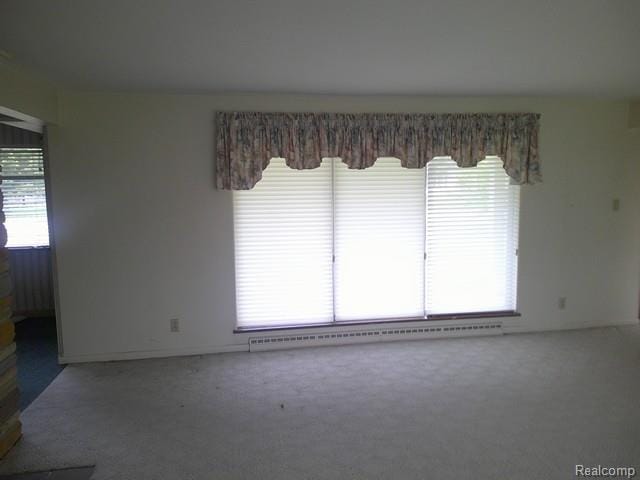 7776 Ash St, Birch Run, MI 48415 - carpeted empty room featuring baseboard heating and plenty of natural light