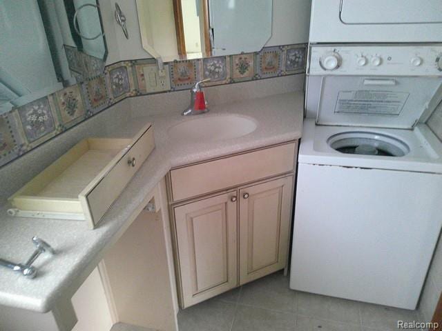 7776 Ash St, Birch Run, MI 48415 - laundry room featuring estacked washer and dryer and light tile patterned floors