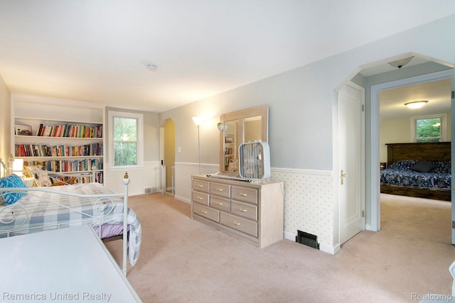 9309 Newburgh Rd, Livonia, MI 48150 - bedroom featuring arched walkways, wainscoting, and light colored carpet