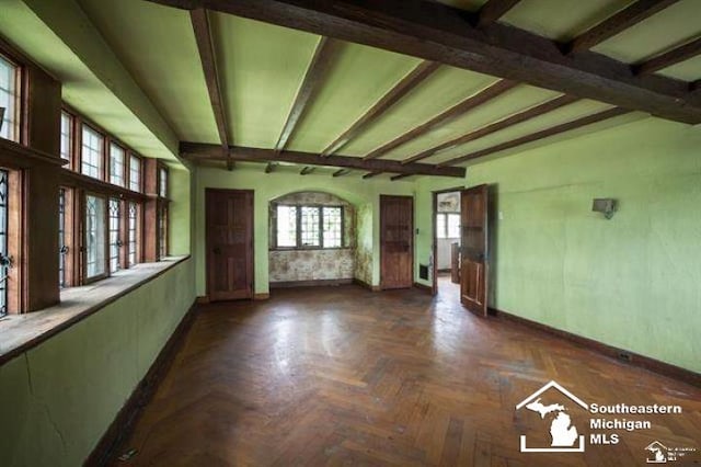 1989 W Grand Blvd, Detroit, MI 48208 - unfurnished living room featuring baseboards and beamed ceiling