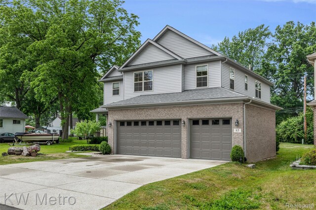 85 Hickory Dr, Troy, MI 48083 - traditional home with an attached garage, concrete driveway, brick siding, and a front yard