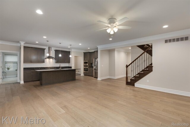 85 Hickory Dr, Troy, MI 48083 - kitchen with open floor plan, appliances with stainless steel finishes, wall chimney exhaust hood, backsplash, and dark brown cabinetry