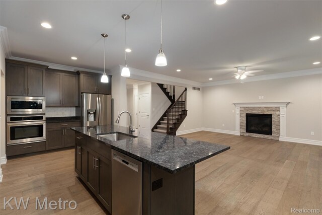 85 Hickory Dr, Troy, MI 48083 - kitchen with stainless steel appliances, a ceiling fan, dark brown cabinetry, tasteful backsplash, and ornamental molding