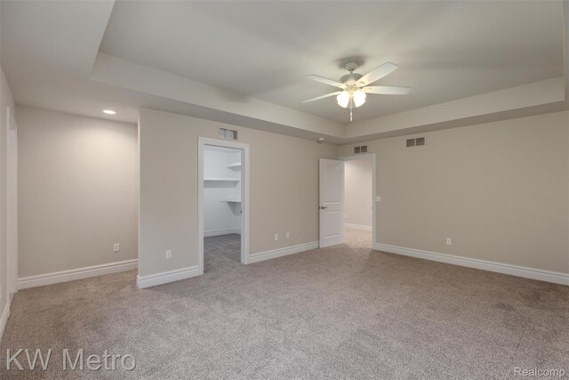 85 Hickory Dr, Troy, MI 48083 - unfurnished bedroom featuring carpet floors, a walk in closet, a raised ceiling, recessed lighting, and a ceiling fan