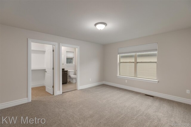 85 Hickory Dr, Troy, MI 48083 - unfurnished bedroom with carpet, a walk in closet, connected bathroom, and a closet