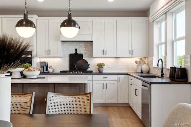 873 Risdon Trl S, Saline, MI 48176 - kitchen with stainless steel dishwasher, tasteful backsplash, stovetop, white cabinetry, and light wood finished floors