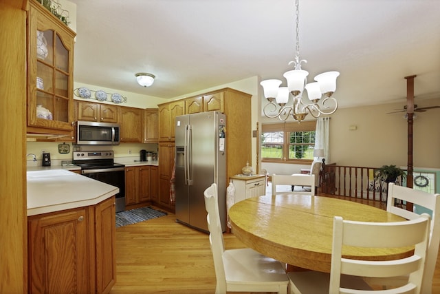 5852 Pinkerton Rd, Vassar, MI 48768 - kitchen featuring stainless steel appliances, a chandelier, brown cabinetry, and light wood finished floors