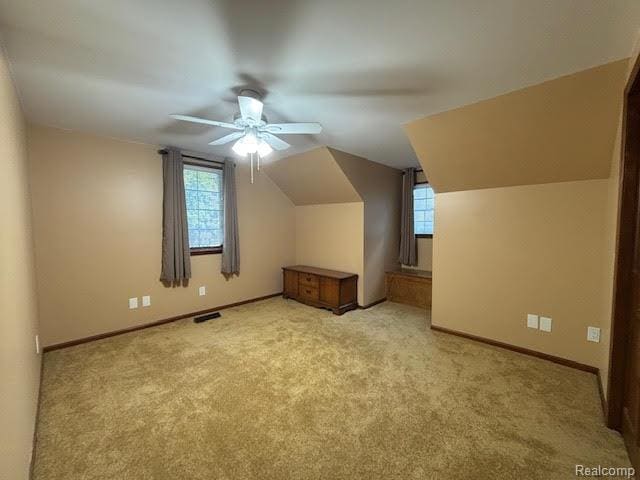 171 Golfview Dr, Caro, MI 48723 - additional living space with healthy amount of natural light, light carpet, a ceiling fan, and lofted ceiling