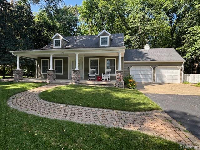 171 Golfview Dr, Caro, MI 48723 - new england style home with a garage, driveway, covered porch, and a front yard