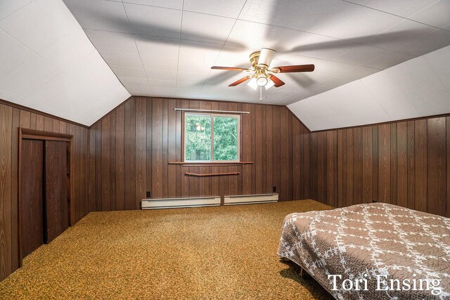 4366 Woods Rd, Sidney, MI 48885 - bedroom featuring a baseboard heating unit, wood walls, vaulted ceiling, carpet, and a ceiling fan
