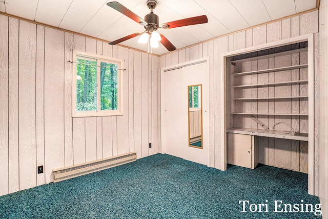 4366 Woods Rd, Sidney, MI 48885 - unfurnished bedroom featuring baseboard heating, wooden walls, carpet floors, and a ceiling fan