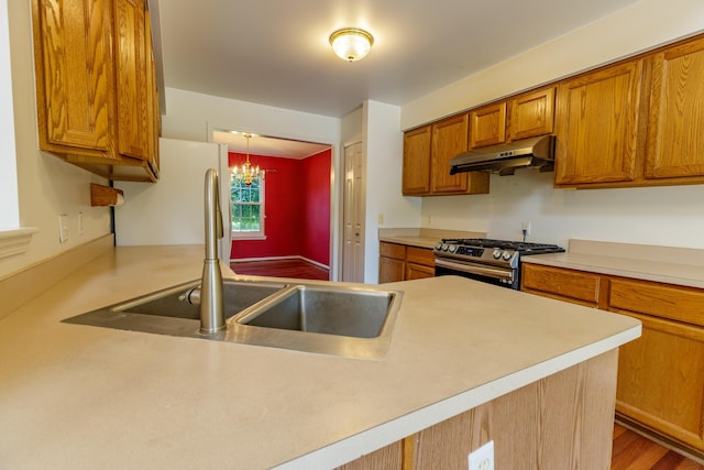 2683 Mystic Dr, Ann Arbor, MI 48103 - kitchen with under cabinet range hood, stainless steel range with gas stovetop, brown cabinets, and light countertops
