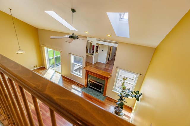 2683 Mystic Dr, Ann Arbor, MI 48103 - living area with a skylight, high vaulted ceiling, a fireplace, wood finished floors, and ceiling fan