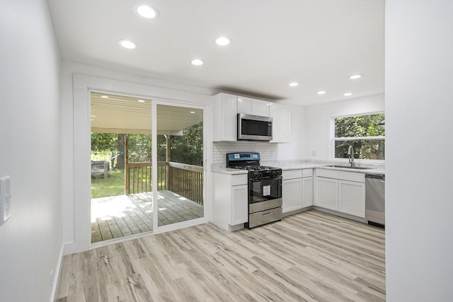 3914 Clarnin St, Kalamazoo, MI 49004 - kitchen with stainless steel appliances, recessed lighting, white cabinetry, decorative backsplash, and light wood-style floors