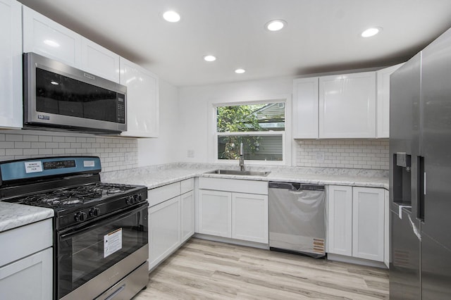 3914 Clarnin St, Kalamazoo, MI 49004 - kitchen featuring stainless steel appliances, recessed lighting, white cabinetry, backsplash, and light wood-type flooring