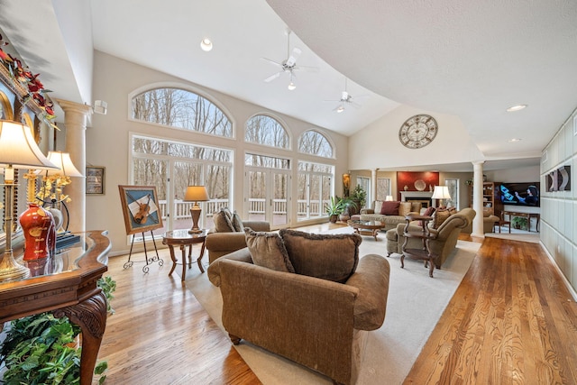 10185 N 650 E, Indiana, IN 46552 - living area with decorative columns, ceiling fan, light wood-style flooring, a glass covered fireplace, and high vaulted ceiling