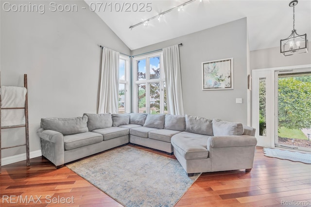 220 E Rolston Rd, Linden, MI 48451 - living room with track lighting, hardwood / wood-style flooring, a chandelier, and high vaulted ceiling