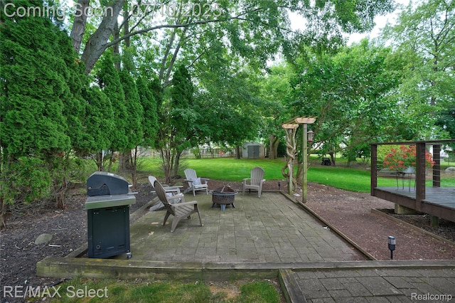 220 E Rolston Rd, Linden, MI 48451 - view of patio featuring an outdoor fire pit, a storage unit, a grill, and a wooden deck