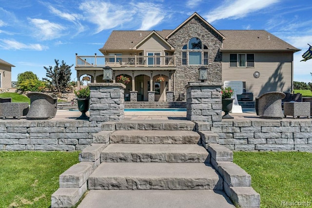 11068 Meadowview Dr, Goodrich, MI 48438 - rear view of property featuring a patio, stone siding, and a wooden deck