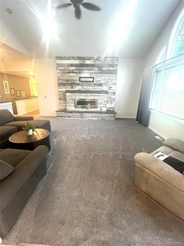11068 Meadowview Dr, Goodrich, MI 48438 - carpeted living area featuring lofted ceiling, a ceiling fan, and a stone fireplace