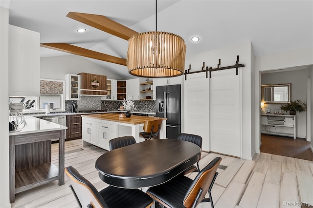 11068 Meadowview Dr, Goodrich, MI 48438 - dining room with a barn door, light wood-style floors, and a chandelier