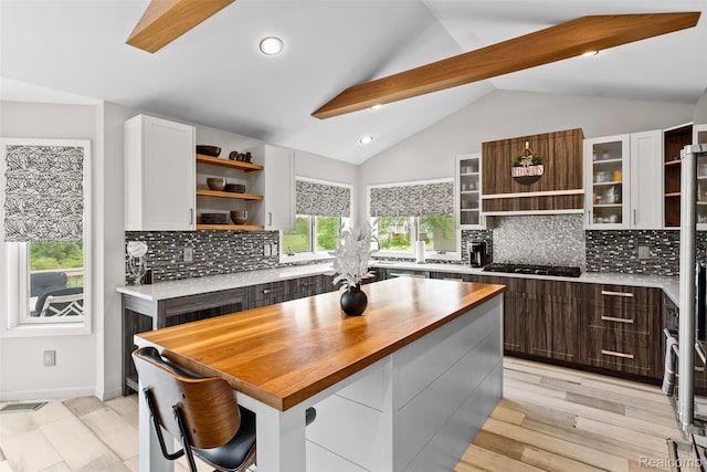11068 Meadowview Dr, Goodrich, MI 48438 - kitchen with open shelves, stainless steel gas stovetop, wooden counters, lofted ceiling, and white cabinetry