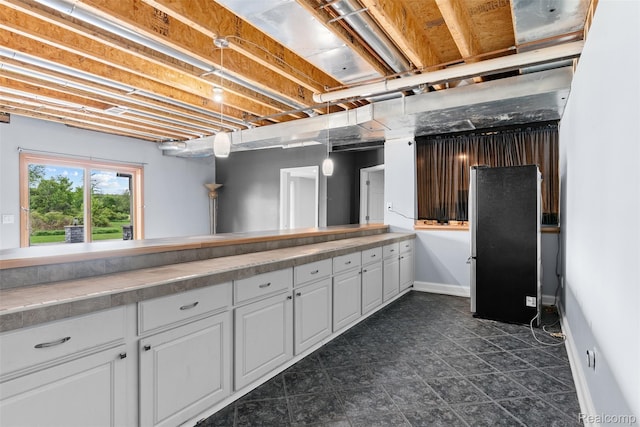 11068 Meadowview Dr, Goodrich, MI 48438 - below grade area featuring freestanding refrigerator and baseboards