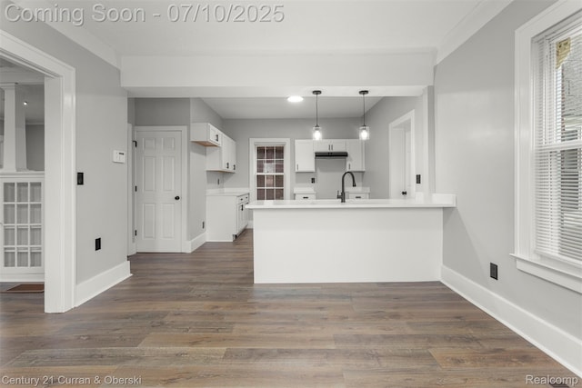 4115 Montgomery St, Detroit, MI 48204 - kitchen with a peninsula, white cabinets, dark wood finished floors, decorative light fixtures, and light countertops