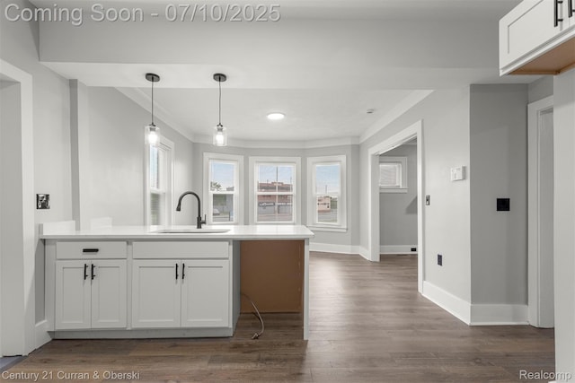 4115 Montgomery St, Detroit, MI 48204 - kitchen featuring a peninsula, crown molding, dark wood-type flooring, white cabinetry, and light countertops