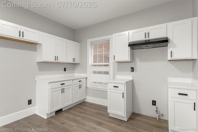 4115 Montgomery St, Detroit, MI 48204 - kitchen with under cabinet range hood, white cabinetry, wood finished floors, and light countertops
