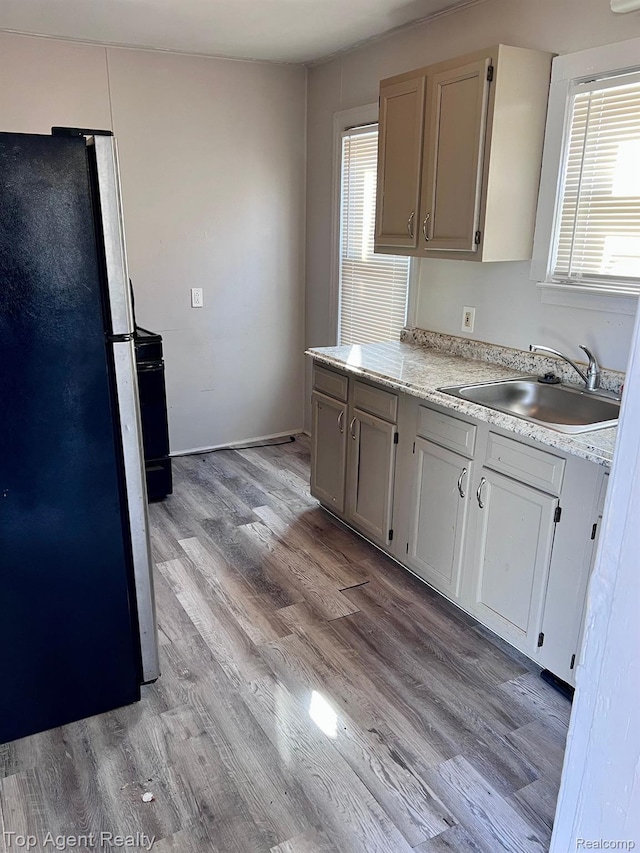 7511 Orchard Ave, Warren, MI 48091 - kitchen with freestanding refrigerator, light countertops, and light wood-style floors