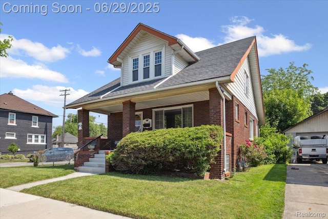 103 Elm St, River Rouge, MI 48218 - view of front of house featuring covered porch, brick siding, a front yard, and roof with shingles