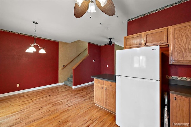 366 Marshall St, Ferndale, MI 48220 - kitchen with freestanding refrigerator, light wood finished floors, dark countertops, a ceiling fan, and hanging light fixtures