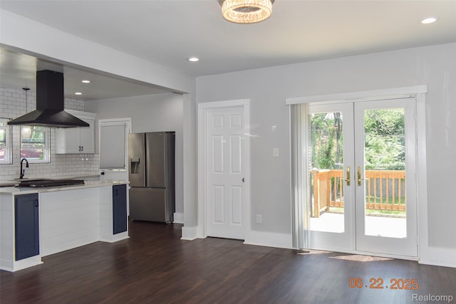 kitchen featuring stainless steel fridge with ice dispenser, island exhaust hood, light countertops, dark wood-type flooring, and french doors