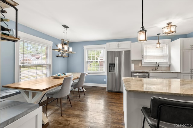 1609 Catalpa Dr, Berkley, MI 48072 - kitchen with appliances with stainless steel finishes, dark wood-style floors, light stone countertops, decorative backsplash, and white cabinets