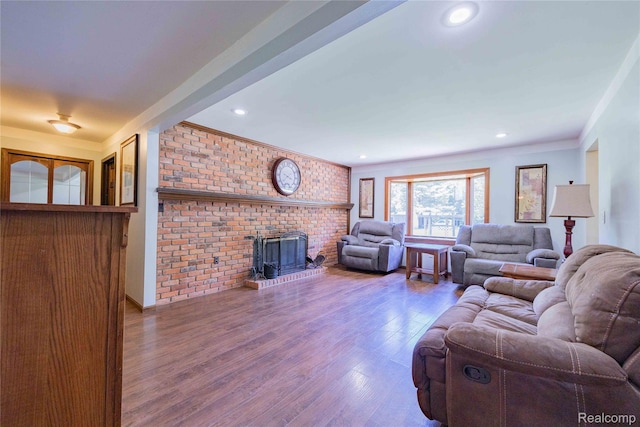 21128 Middlebelt Rd, New Boston, MI 48164 - living room featuring wood finished floors, brick wall, recessed lighting, crown molding, and a wood stove