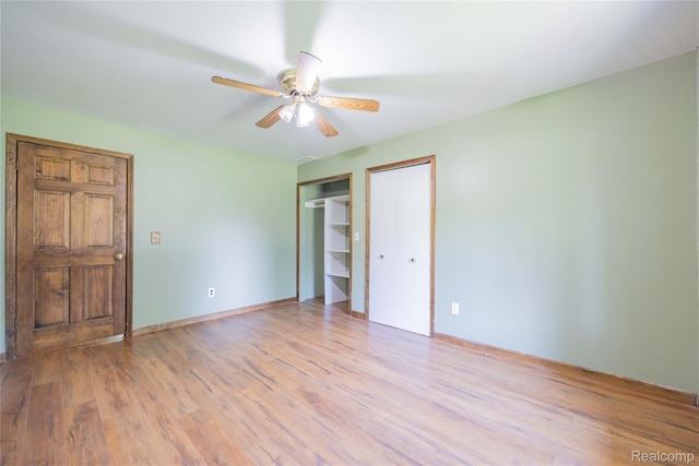 21128 Middlebelt Rd, New Boston, MI 48164 - unfurnished bedroom featuring light wood-type flooring, two closets, and ceiling fan