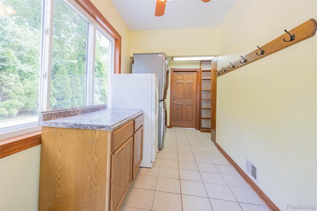 21128 Middlebelt Rd, New Boston, MI 48164 - kitchen with light tile patterned floors, a ceiling fan, freestanding refrigerator, and light countertops