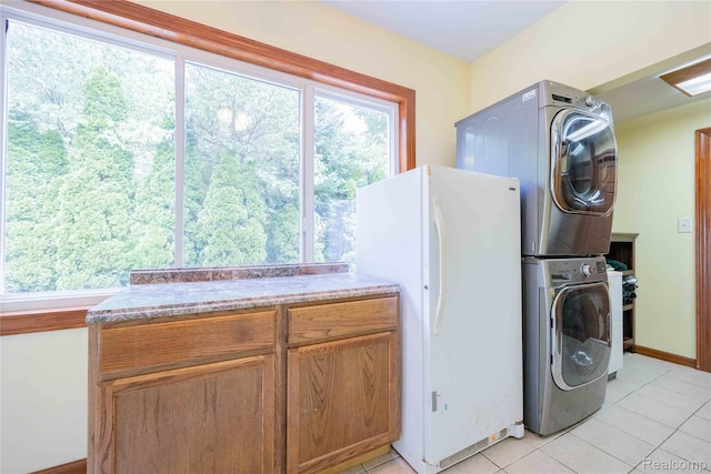 21128 Middlebelt Rd, New Boston, MI 48164 - laundry area with stacked washing machine and dryer, cabinet space, and light tile patterned flooring